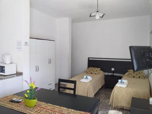 Zimmer mit 2 Betten, einem Tisch und einem TV in der Unterkunft Bella Vista Apart in Chilecito