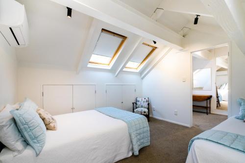 a bedroom with two beds and two windows at Lawn Road Retreat in Clive