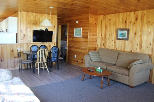 a living room with a couch and a table at Chalets Grand Pre Cottages in North Rustico