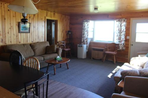 a living room with a couch and a table at Chalets Grand Pre Cottages in North Rustico