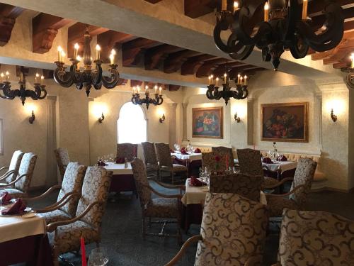 a dining room with tables and chairs and a chandelier at Grand Isla Navidad Golf & Spa Resort with Marina in Barra de Navidad