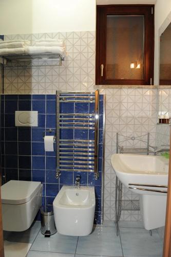a blue tiled bathroom with a toilet and a sink at Country House Il Papavero in Bagnoli Irpino