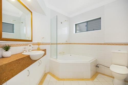uma casa de banho com uma banheira, um lavatório e um WC. em Breakers 2 12 - LJHooker Yamba em Yamba