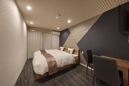 a bedroom with a bed and a desk with a computer at Stay SAKURA Kyoto Matsuri in Kyoto
