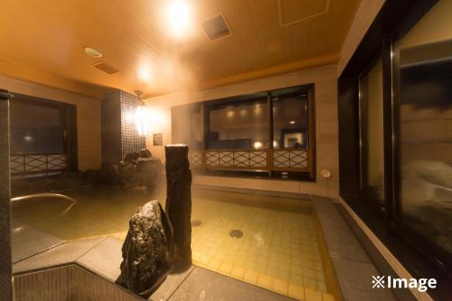 a bathroom with a bath tub and a shower with a tub at Onyado Nono Asakusa Natural Hot Spring in Tokyo