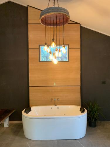 a bath tub in a room with a chandelier at The Rocks Apartments in Halls Gap