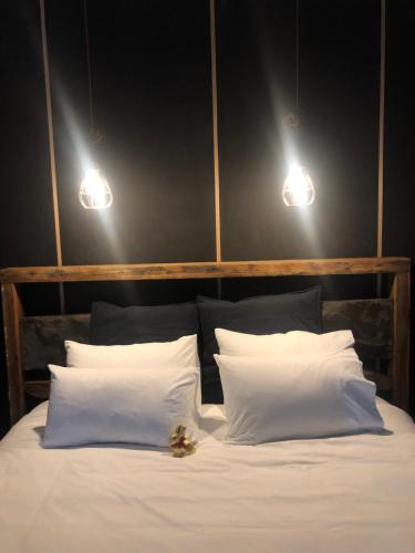 a bed with two white pillows and two lights at The Rocks Apartments in Halls Gap