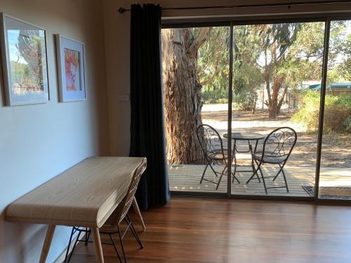 a room with a table and chairs and a sliding glass door at The Rocks Apartments in Halls Gap