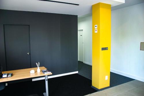 an office with a yellow pillar in the middle of a room at Parnell Pines Hotel in Auckland