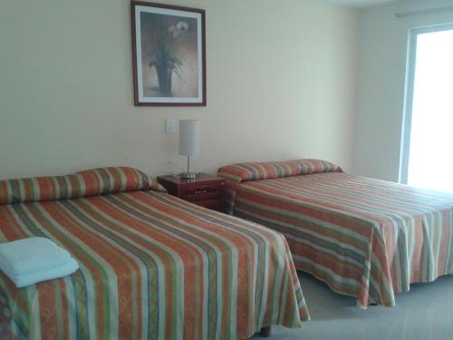 a hotel room with two beds and a picture on the wall at Hotel Playa Azul in Catemaco