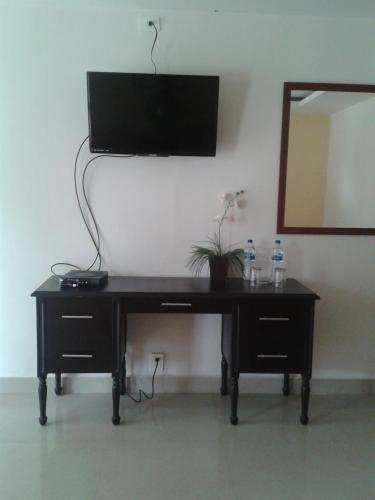 a desk with a television on a wall with a mirror at Hotel Playa Azul in Catemaco