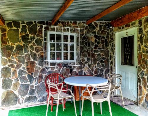 a table and chairs in front of a stone wall at Windmill Hostal in Valle de Anton
