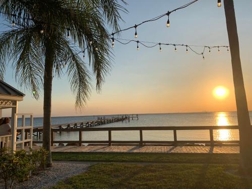 a view of the beach at sunset with a pier at TAMPA BAY, BEACH step away, WIFI, FREE PARKING,POOLS, JACUZZI in Ruskin