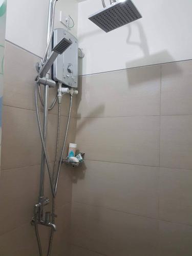 a shower in a bathroom with a shower head at Condo at SMDC Wind Residences Tagaytay in Tagaytay