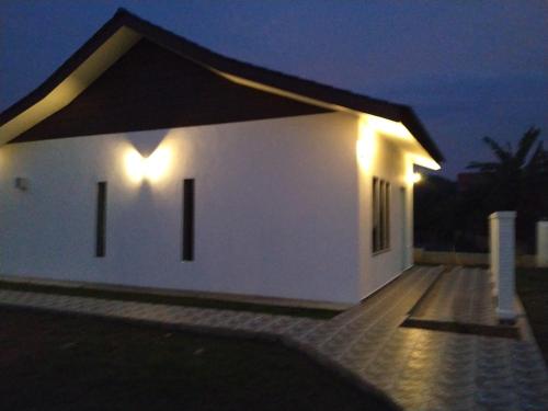a white house with lights on the side of it at Halcyon Days @ Langkawi in Pantai Cenang