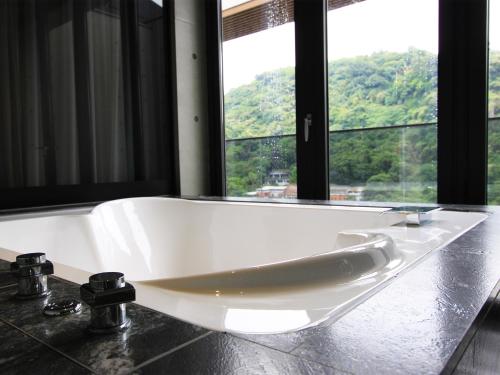 a white bath tub in a bathroom with a window at The Tango Hotel Taipei Jiantan in Taipei