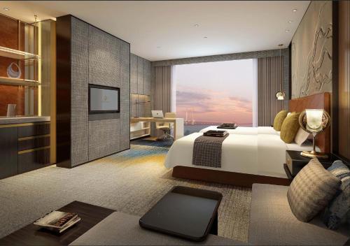 InterContinental Zhuhai, an IHG Hotel في تشوهاى: غرفة فندقية بسرير ونافذة كبيرة