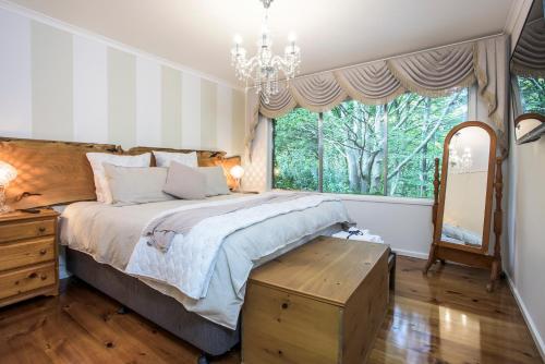a bedroom with a large bed and a large window at The Beeches - Olinda in Olinda