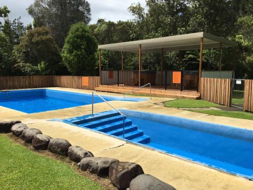 a swimming pool with a gazebo in a yard at Sapphire Springs Holiday Park and Thermal Pools in Katikati