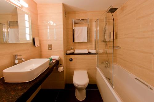 a bathroom with a sink and a toilet and a shower at The Collection Hotel Birmingham in Birmingham