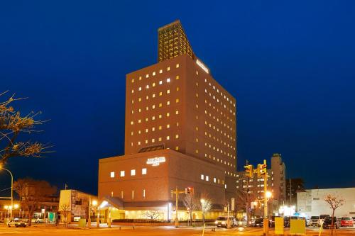 a tall building in a city at night at ART HOTEL Aomori in Aomori