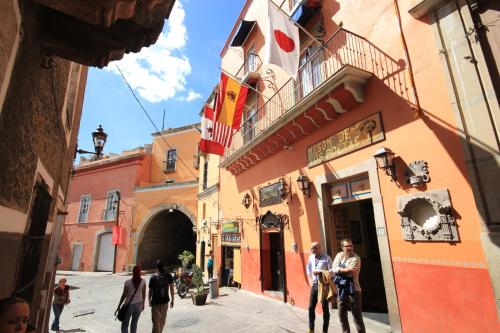 a group of people walking down a street at El Meson de los Poetas in Guanajuato