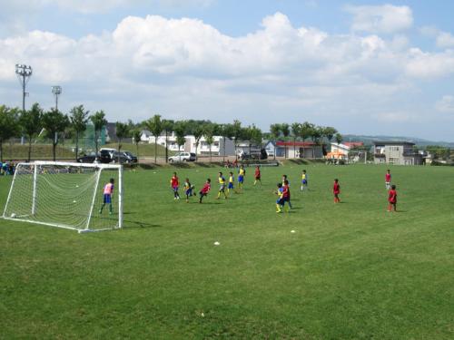 a group of children playing soccer on a field at Sunhills Sarai in Shintotsukawa