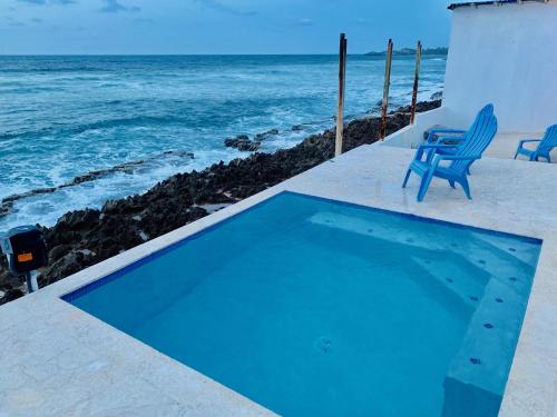 una piscina azul junto al océano en Discovery Inn & Suites at 681 Ocean Drive, en Arecibo