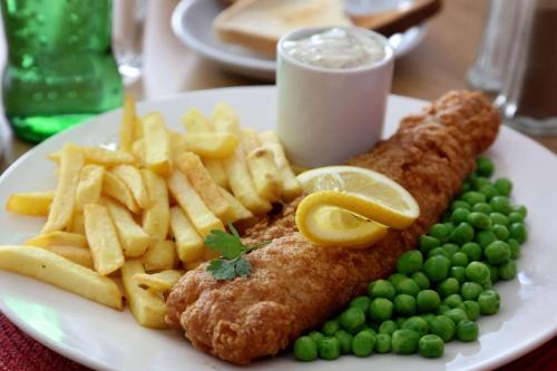 a plate with fish and french fries and peas at Best Western Greater London in Ilford