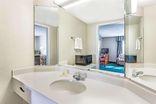 a white bathroom with a sink and a mirror at Days Inn by Wyndham Richmond/South in Richmond