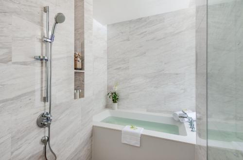 a bathroom with a tub and a shower at Twinpalms MontAzure Phuket in Kamala Beach