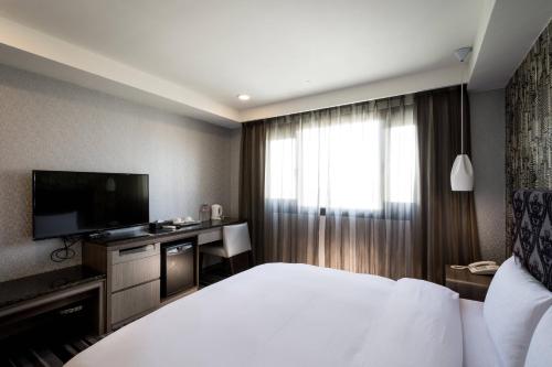 Una televisión o centro de entretenimiento en JUNG-ZAW BUSSINESS HOTEL