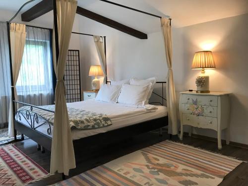 1 dormitorio con cama con dosel y mesa con lámparas en Calea Poienii Penthouse, en Brasov