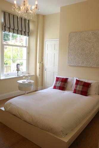 a bedroom with a bed and a window and a chandelier at Dean End Apartment 2 in Ross on Wye