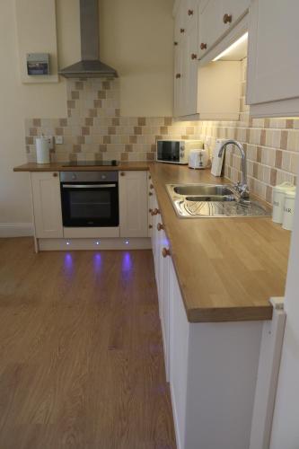 a kitchen with a sink and a stove top oven at Dean End Apartment 2 in Ross on Wye
