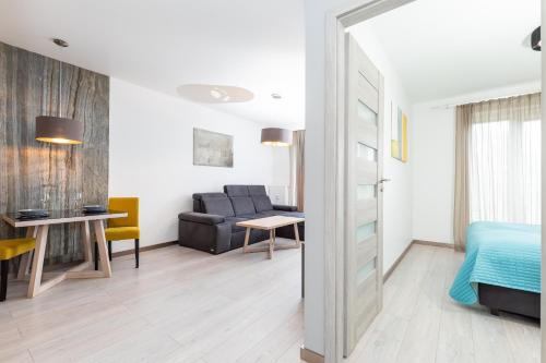 コウォブジェクにあるJantar Apartamenty Residence Solnaのベッド、ソファ、テーブルが備わる客室です。
