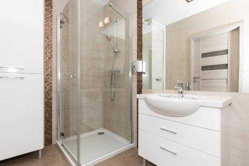 コウォブジェクにあるJantar Apartamenty Residence Solnaの白いバスルーム(シンク、シャワー付)