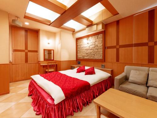 a bedroom with a large bed with a red blanket at Hotel Mine (Love Hotel) in Kurume