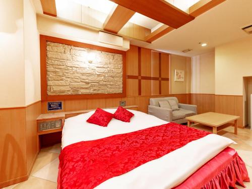 a bedroom with a large bed with red pillows at Hotel Mine (Love Hotel) in Kurume