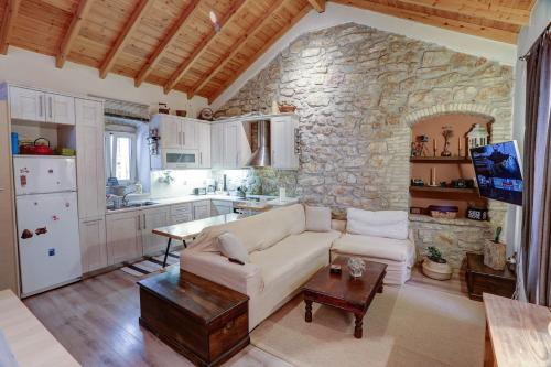 - un salon avec un canapé blanc et un mur en pierre dans l'établissement Luminous 2BD stone Apt in the alleys of Corfu town, à Corfou