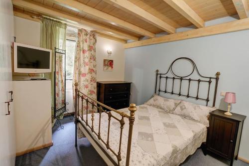 1 dormitorio con 1 cama y TV en una habitación en Luminous 2BD stone Apt in the alleys of Corfu town, en Corfú
