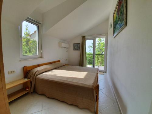 a bedroom with a bed and a window at Villa Rolla in Tivat