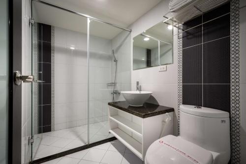 y baño con aseo, lavabo y ducha. en JUNG-ZAW BUSSINESS HOTEL, en Taichung