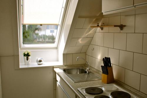 a small kitchen with a sink and a window at Ferienwohnung Bockholm Appartement 1 - 8 in Glücksburg