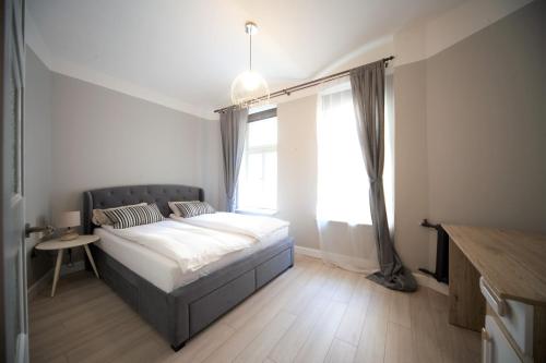 een slaapkamer met een bed en een groot raam bij Valnu street Old Town - quiet area in Rīga