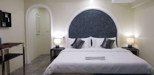 a bedroom with a large bed with an arch above it at Cess Summer Boutique Hotel in Kalibo