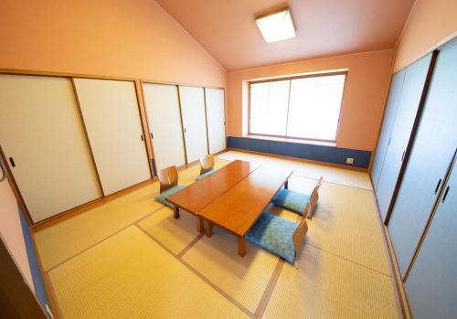 a dining room with a wooden table and chairs at Kinta no sato in Hamada