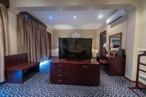 a hotel room with a flat screen tv and a couch at Sunbird Capital in Lilongwe