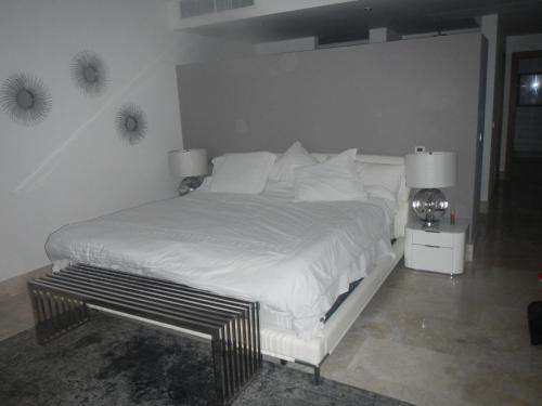 a bed with white sheets and pillows in a bedroom at La Amada Residences Luxury in Cancún