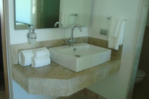 a white sink in a bathroom with towels at La Amada Residences Luxury in Cancún